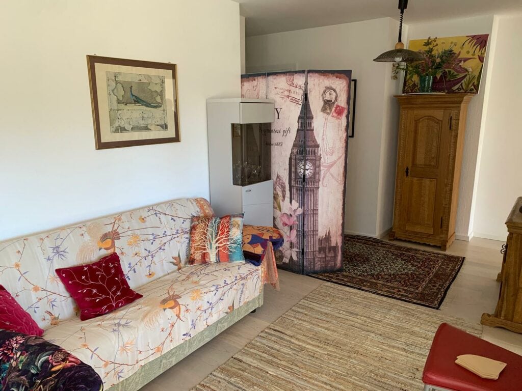 Gemütliches Wohnzimmer mit stilvoller Dekoration, Sofa mit Kissen, antike Möbel und London-Motiv im.